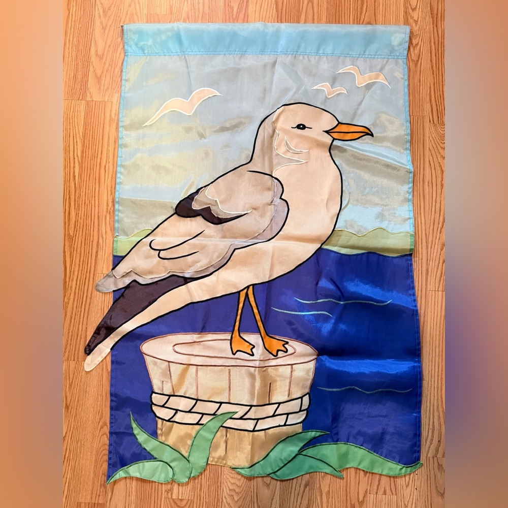 A decorative house or garden flag featuring a California gull.